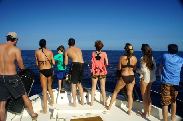 A group of people standing on a boat looking at the ocean