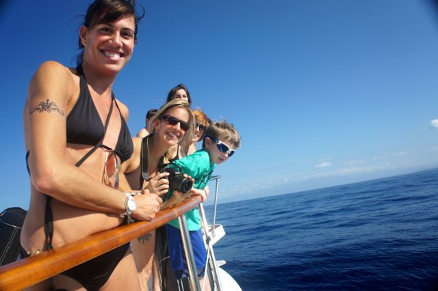 A group of people are standing on a boat in the ocean