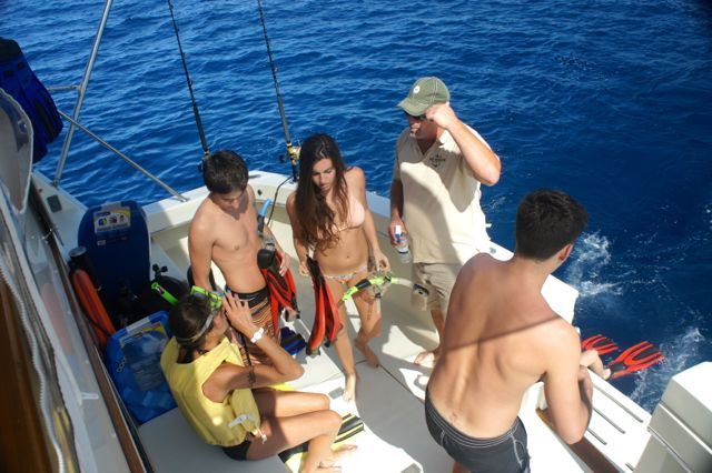 A group of people are sitting on a boat in the ocean