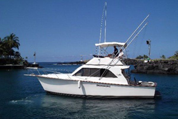A white boat is floating on top of a body of water