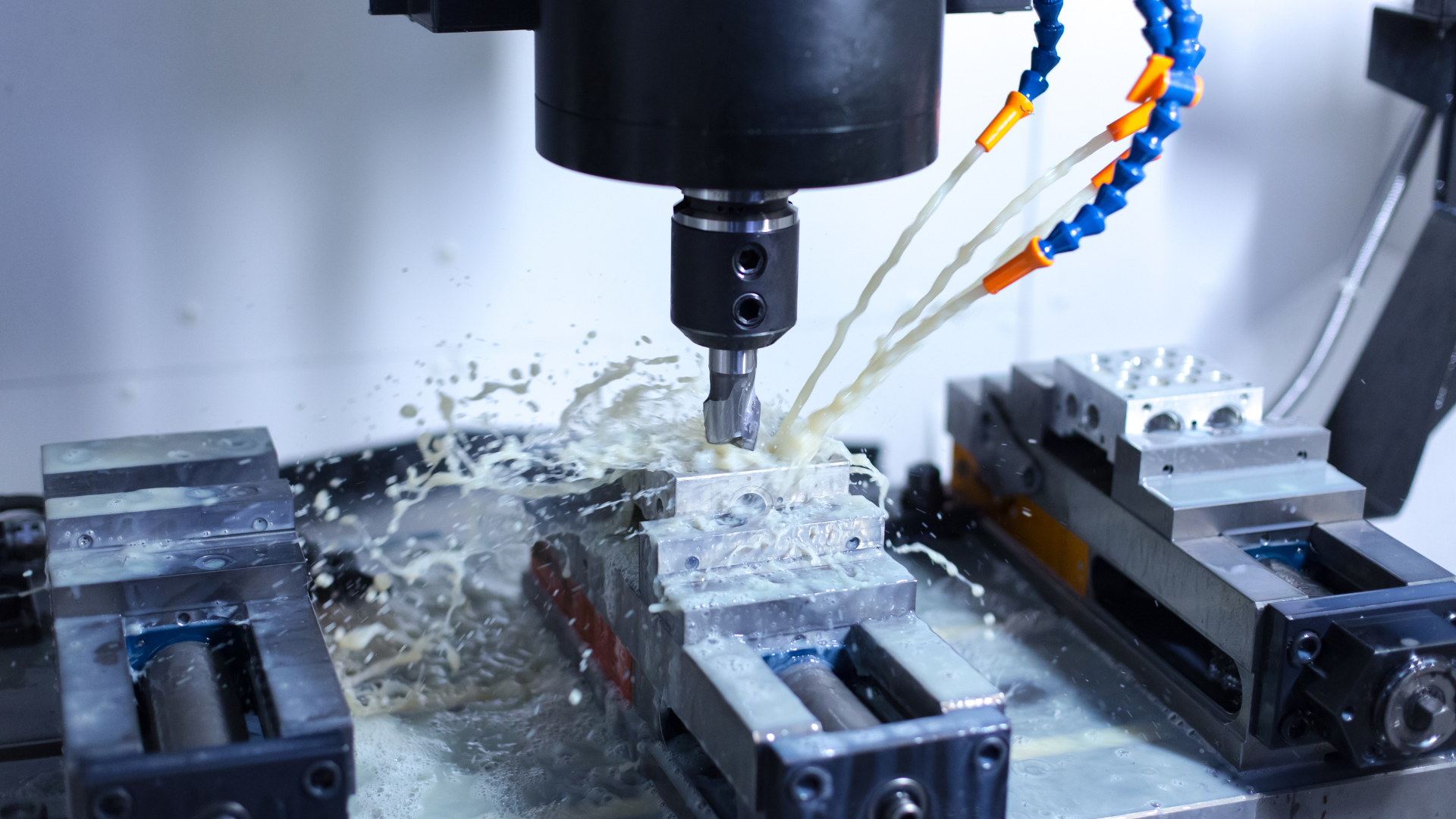 CNC milling machine cutting metal with liquid coolant.