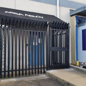 A black fence with a black awning that says assa abloy