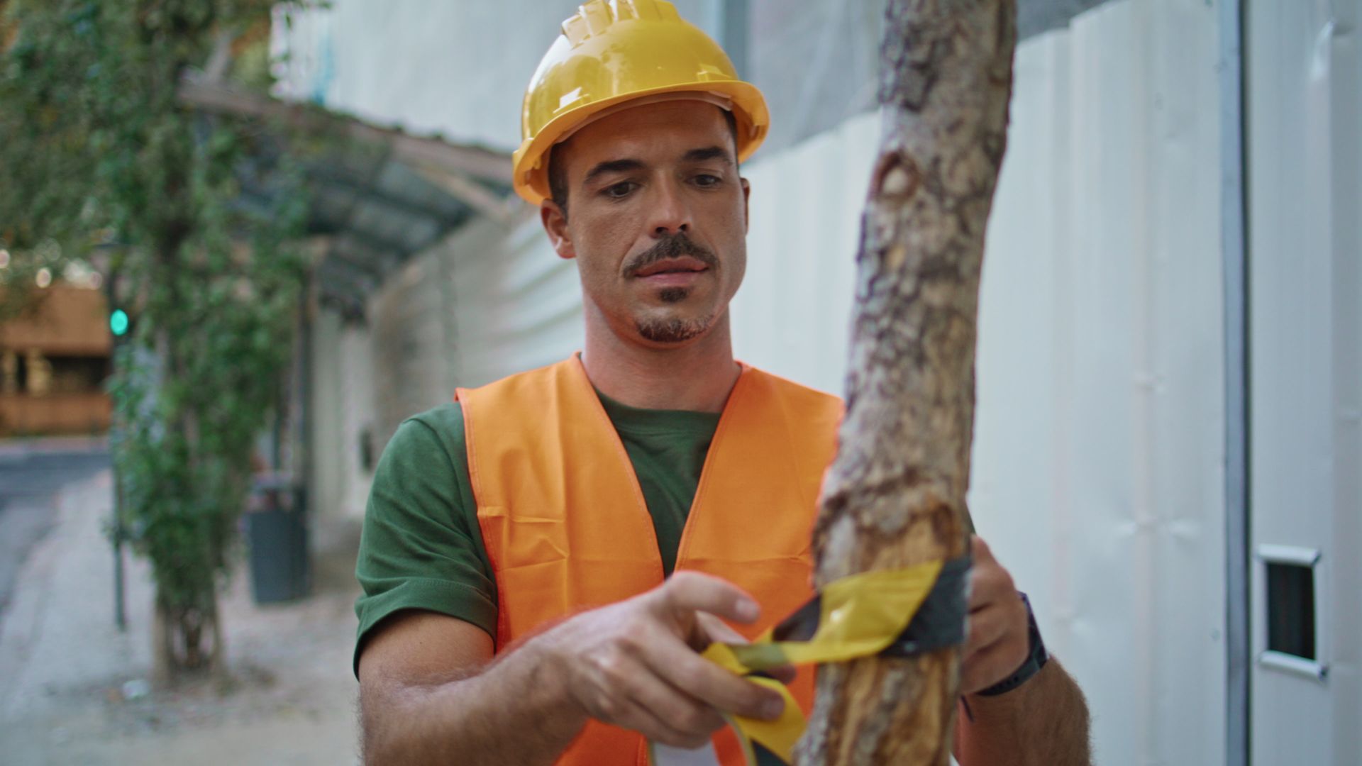 Professional arborist using warning tape for tree work safety protocols