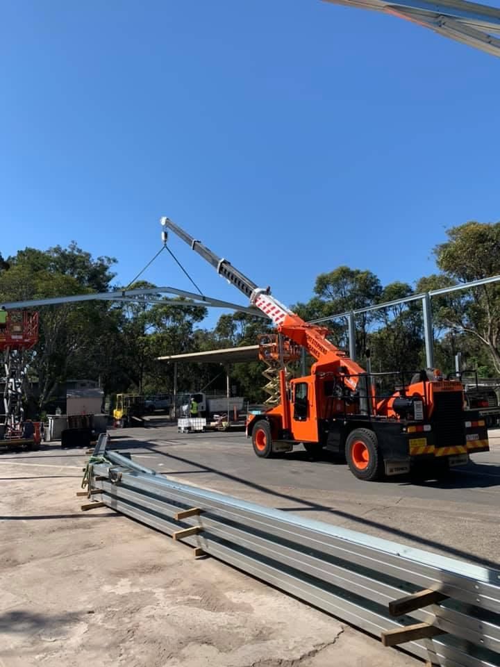 A Crane Is Lifting A Metal Structure In A Parking Lot — Port Stephens Cranes In Port Stephens, NSW