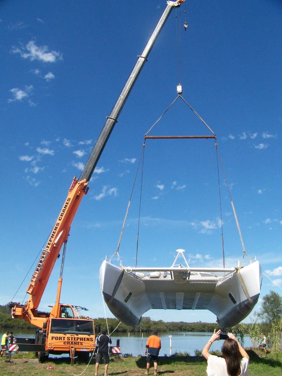 A Crane Is Lifting A Boat Into The Water — Port Stephens Cranes In Salt Ash, NSW