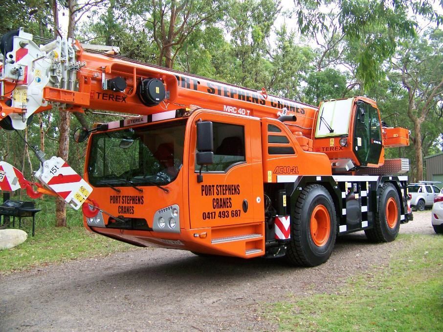 A Large Orange Crane Is Parked On A Dirt Road — Port Stephens Cranes In Salt Ash, NSW