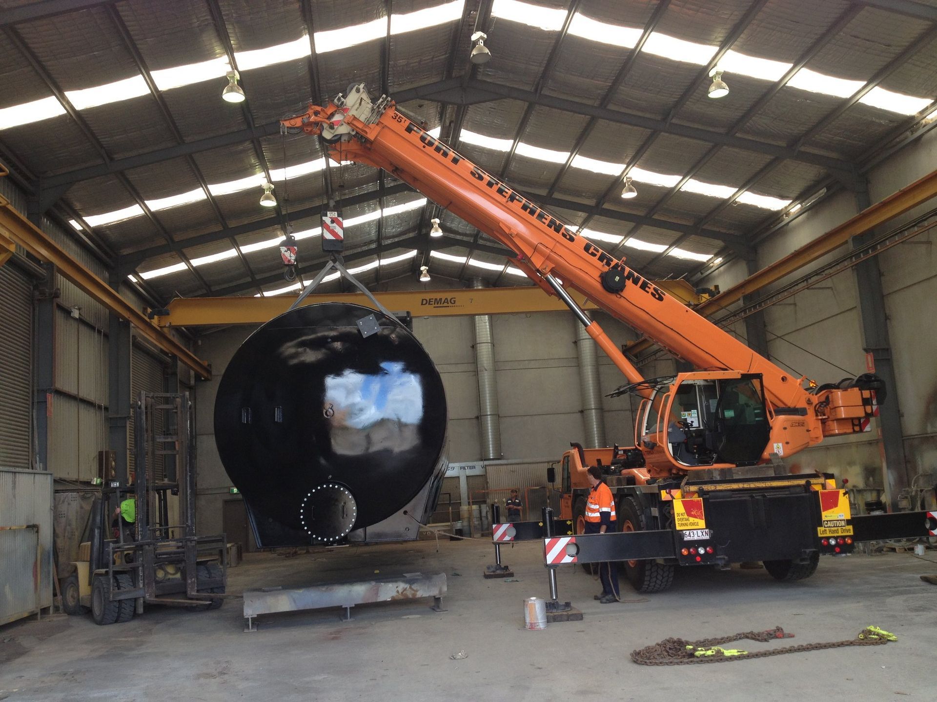 A Man Is Sitting On A Raised Platform On A Crane — Port Stephens Cranes In Medowie, NSW