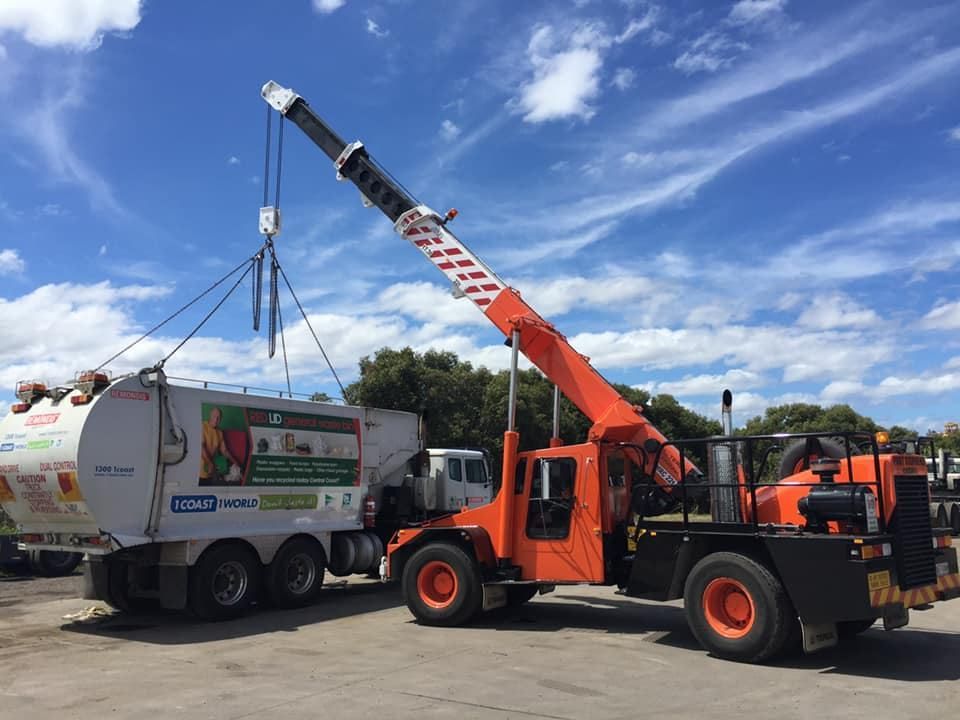 A Crane Is Lifting A Garbage Truck In A Parking Lot — Port Stephens Cranes In Salt Ash, NSW