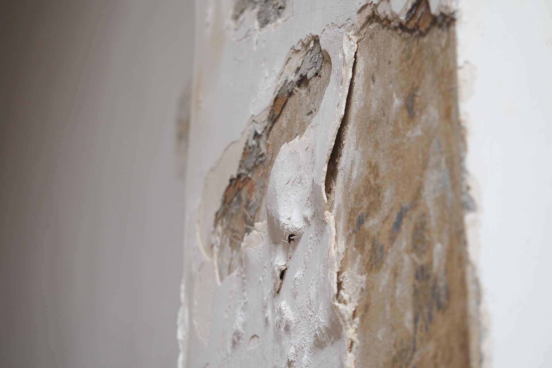 Wall repair work shows damage and restoration process. Wall repair work shows damage and restoration process.