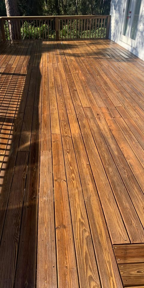 A close up of a wooden deck with a fence in the background.