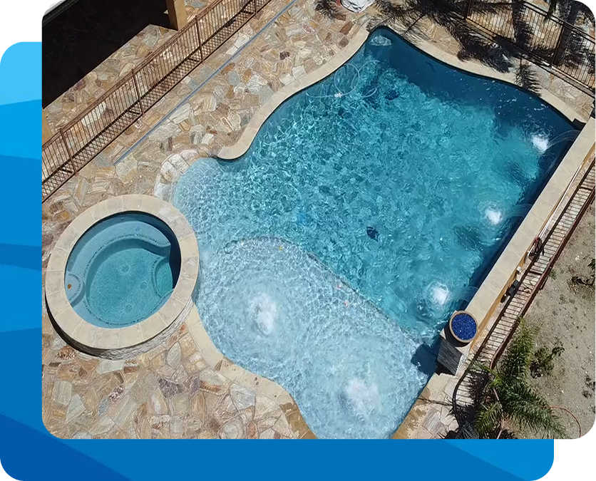 Woman in a blue bikini exiting a pool, smiling. Pool has a ladder, surrounded by greenery.