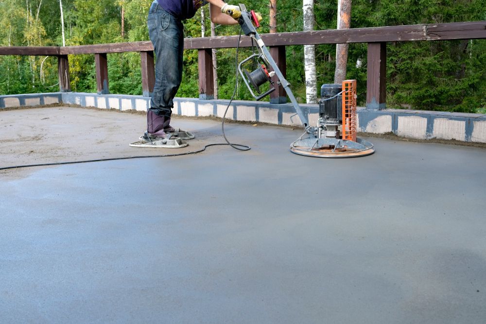 A man is using a machine to finish a concrete floor.