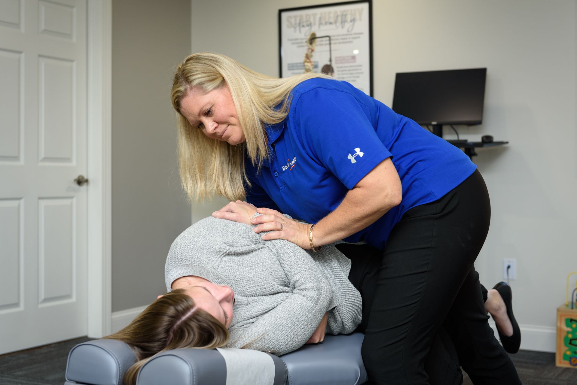 A woman is giving a woman a massage on a table.