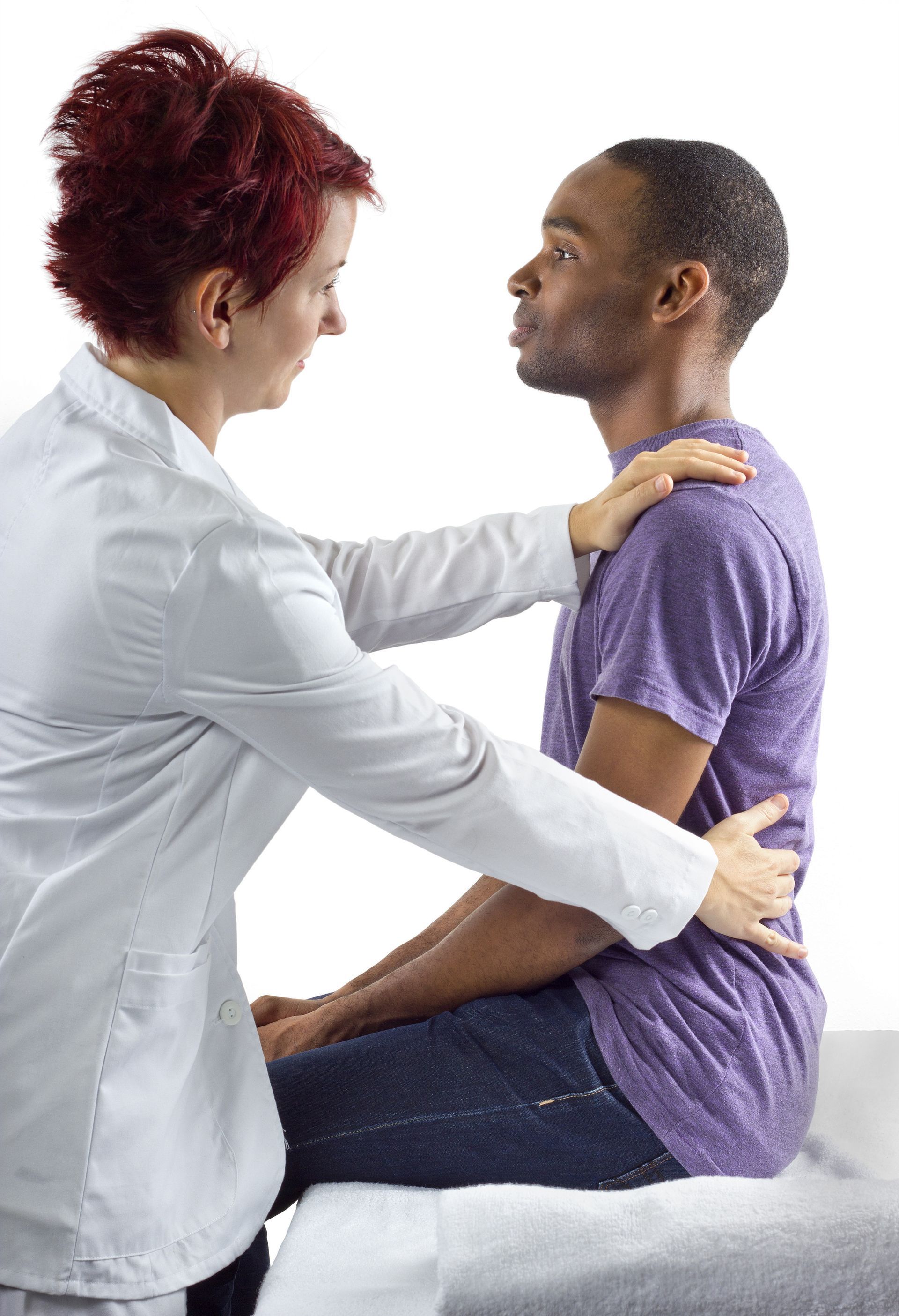 A woman is examining a man 's back while he sits on a table.