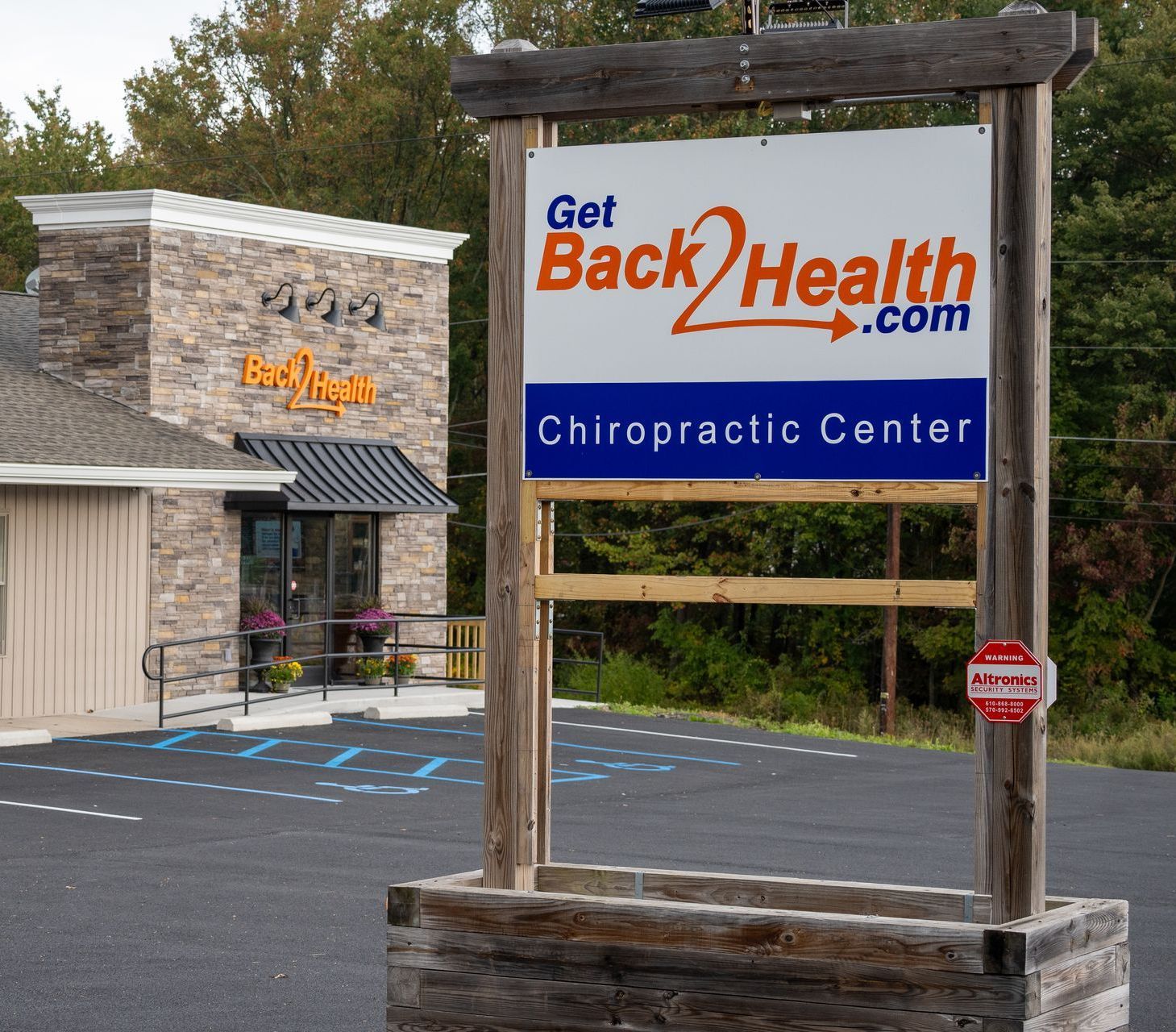 A sign for a chiropractic center says get back2health.com A back health sign on a brick wall