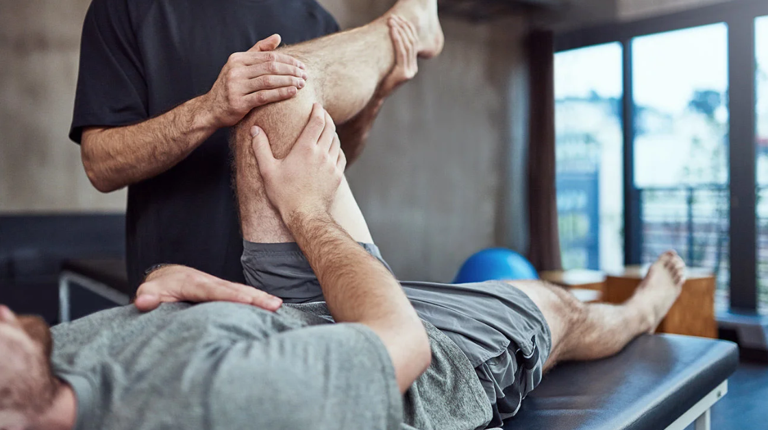 A man is getting a knee massage from a physical therapist.