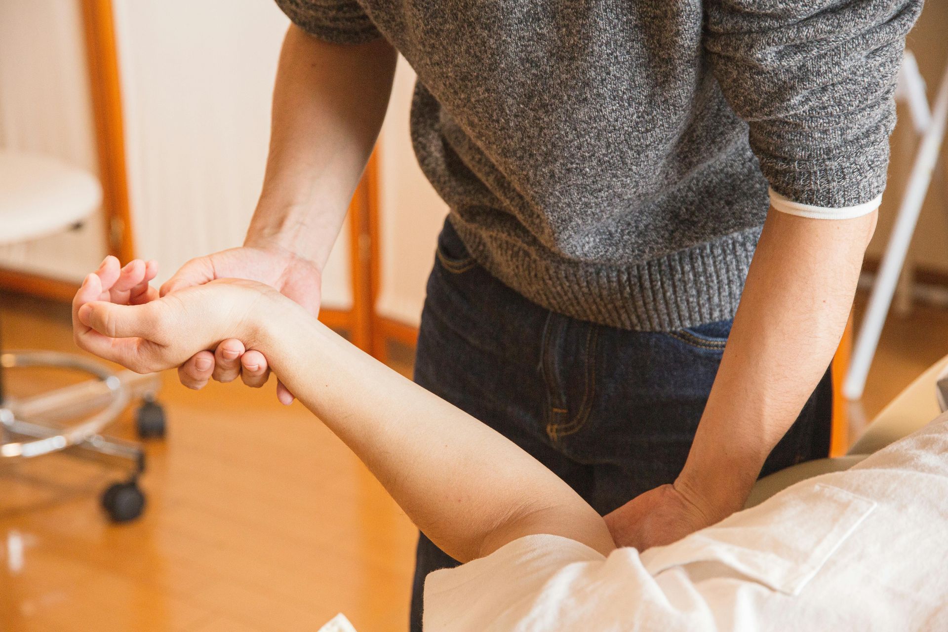 A man is giving a woman a massage on her arm.