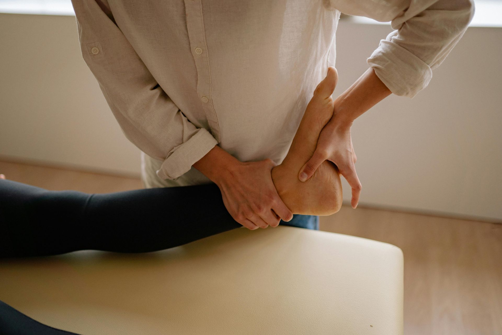 A person is giving a foot massage to another person on a table.