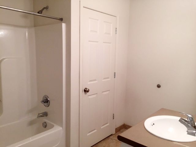 a bathroom with a sink , tub and shower .
