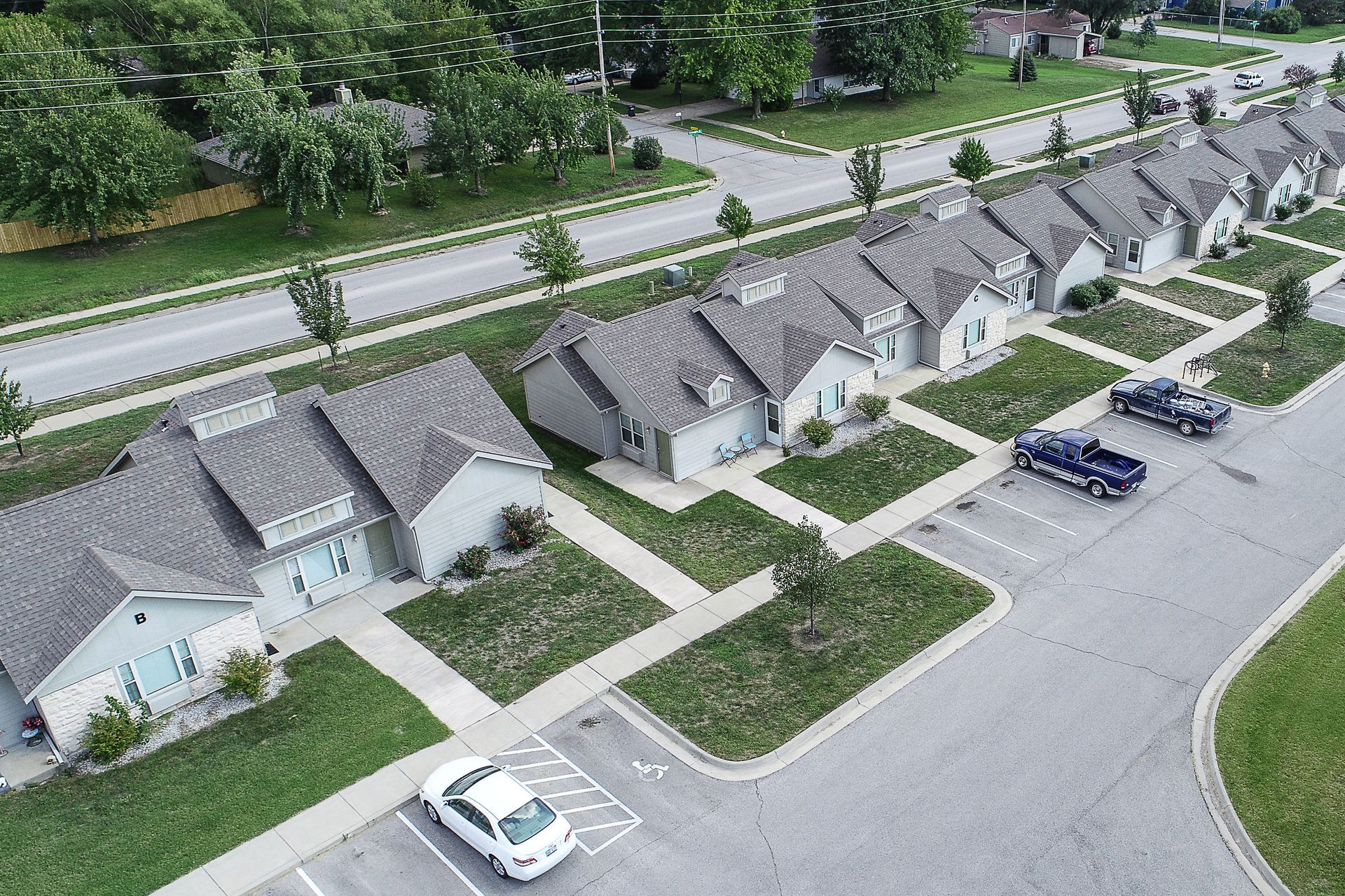 an aerial view of a row of houses with cars parked in front of them