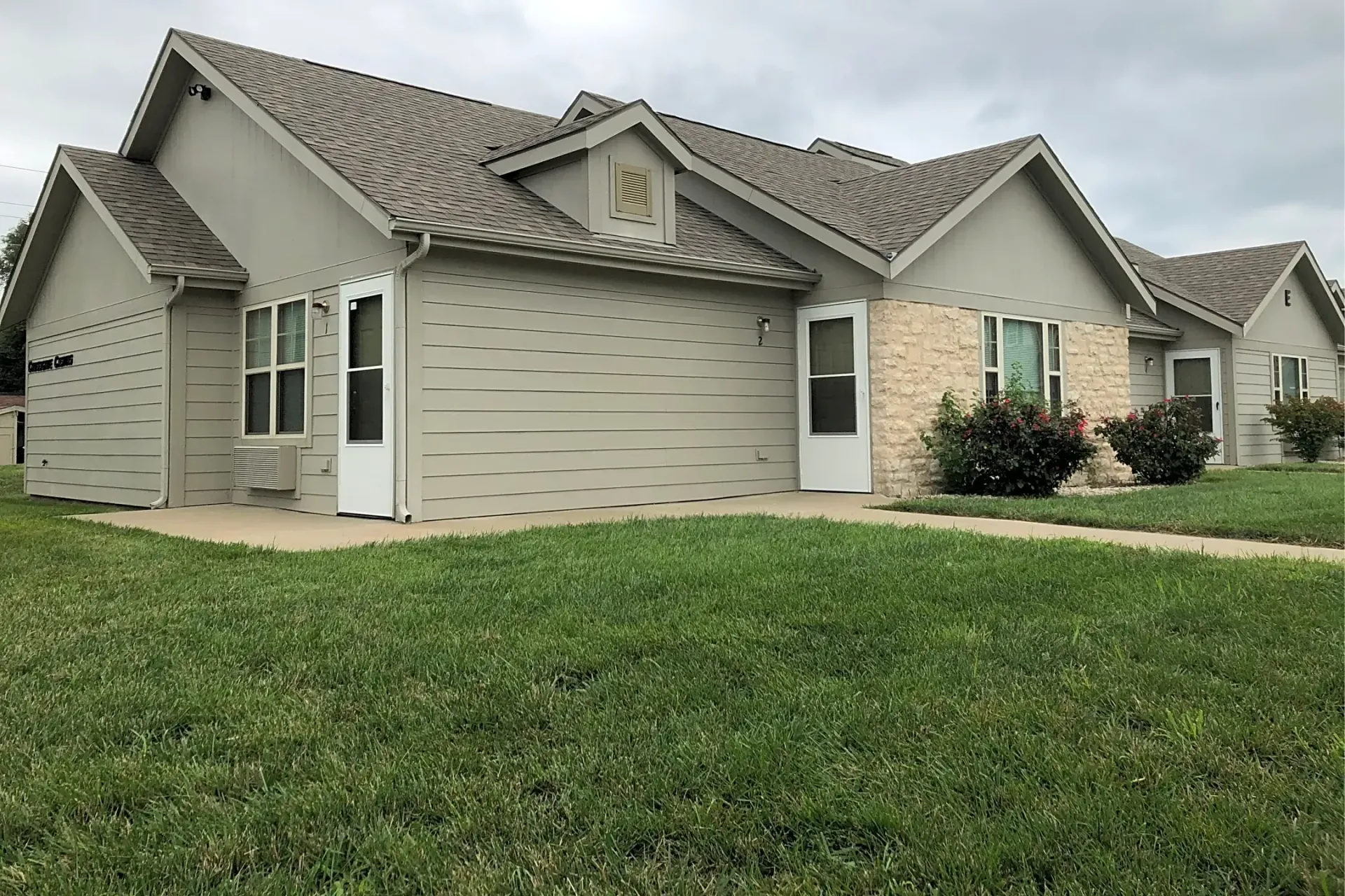 Crossgate Casitas housing with a lush green lawn in front of it .