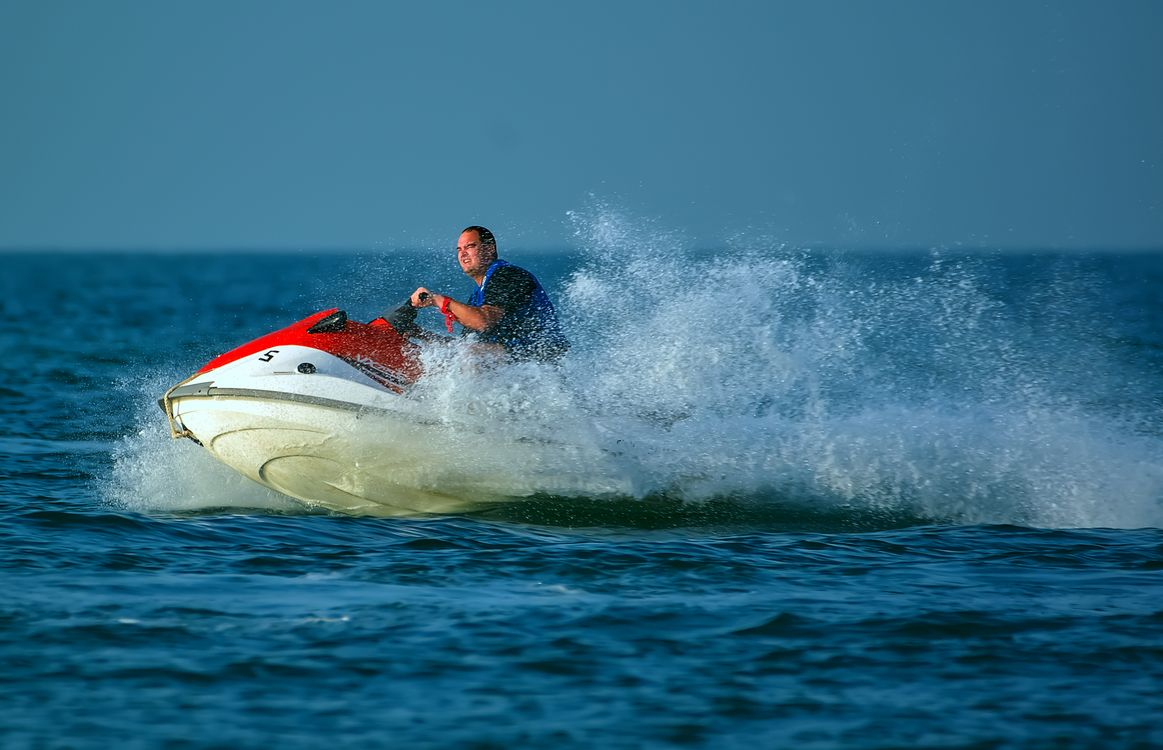 A Man is shown e-foiling on a sunny day.