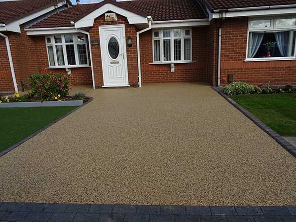 A brick house in Chelmsford with a resin driveway in front of it. Installed by Essex Resin driveways