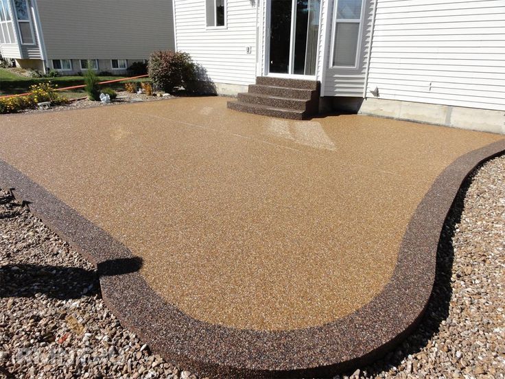 A resin patio in front of a house with stairs. Installed by Essex Resin driveways
