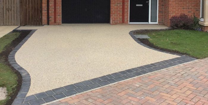 A resin driveway in Essex with a brick border in front of a brick house. Installed by Essex Resin driveways