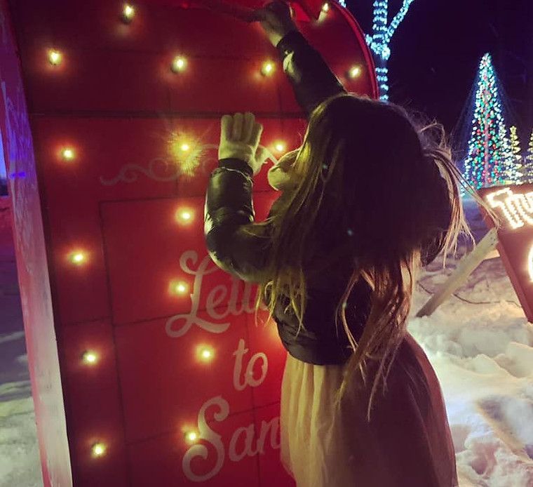 Girl in winter coat placing letter in a