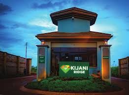 Gatehouse entrance to Kijani Ridge, with a green sign and manicured landscaping.