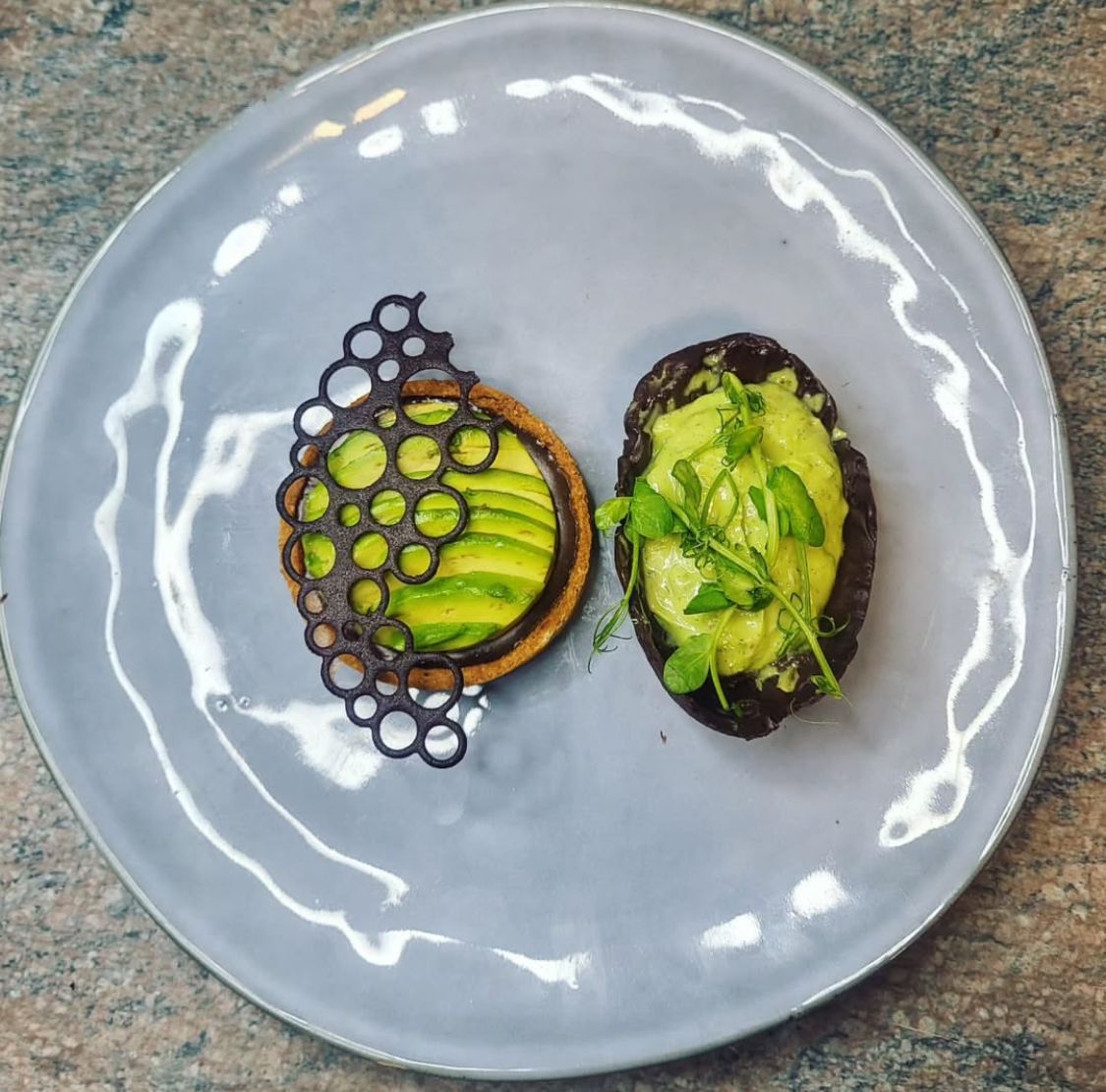 Une assiette de nourriture avec de l'avocat et de la purée de pommes de terre dessus