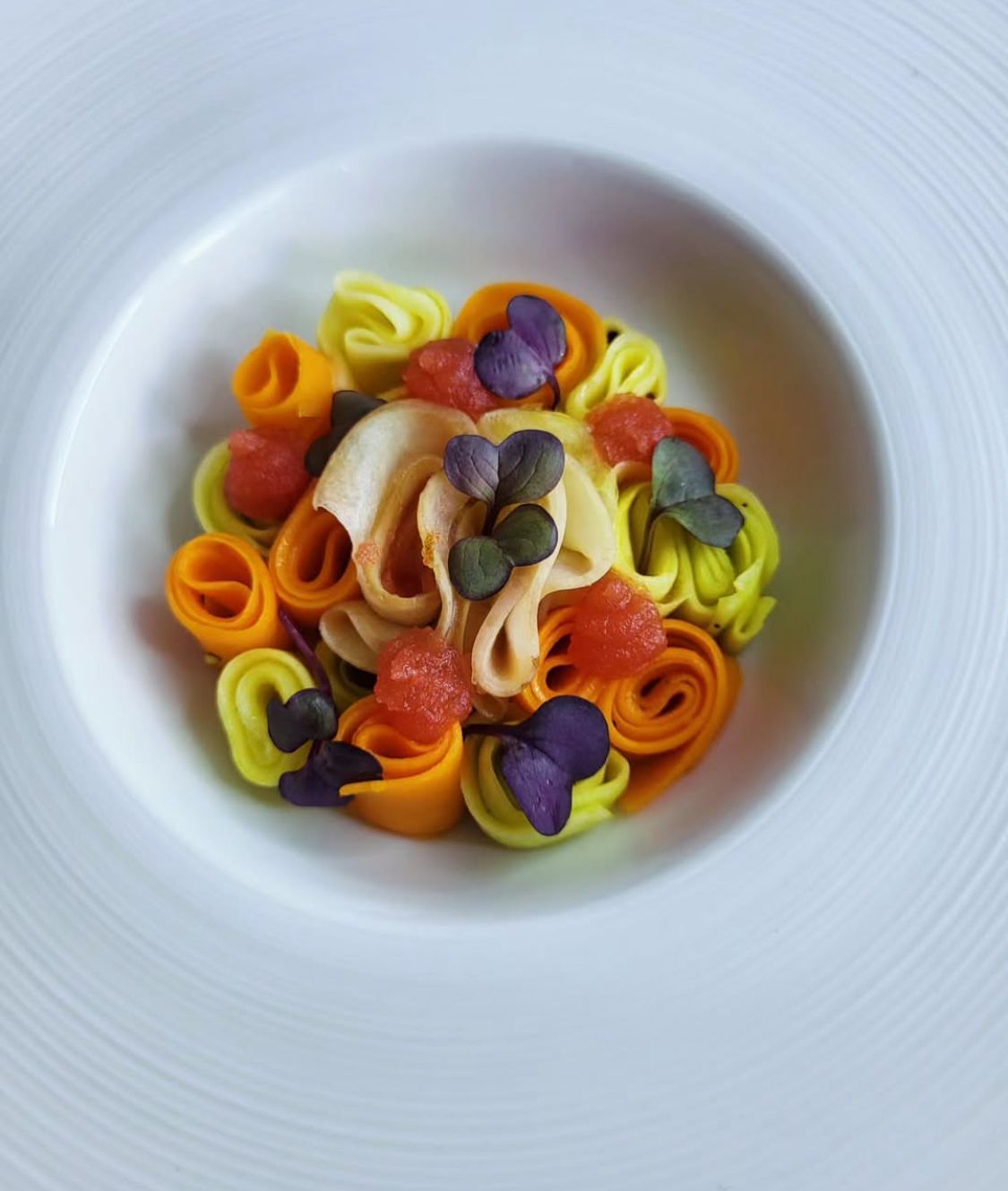 Une assiette blanche garnie de nouilles et de légumes