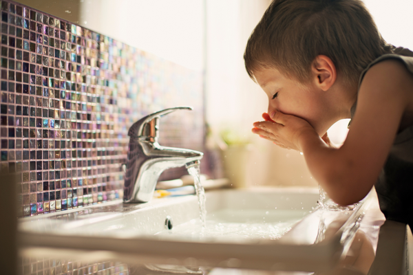Child drinking safe tap water
