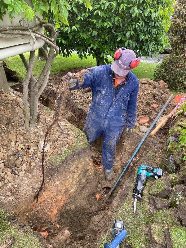 Dunedin plumber Mike Mains working on a drain laying  repair