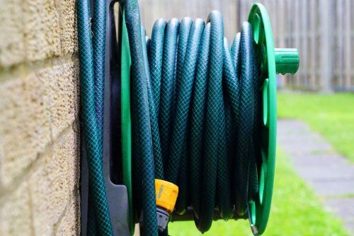 water hose neatly displayed in the backyard