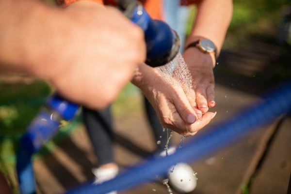 washing hands with water hose