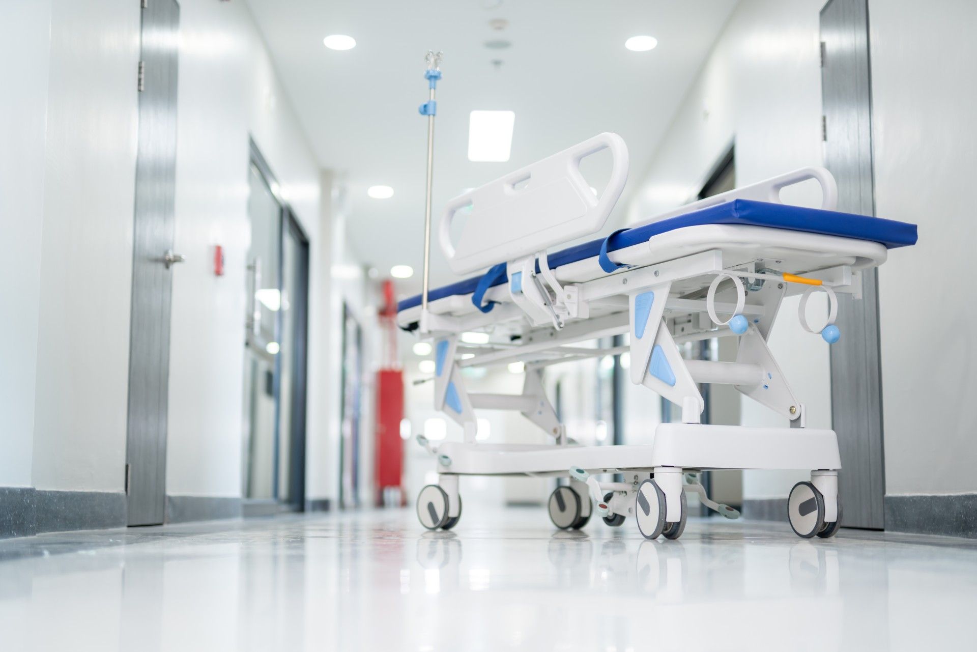 A hospital bed is sitting in the hallway of a hospital.