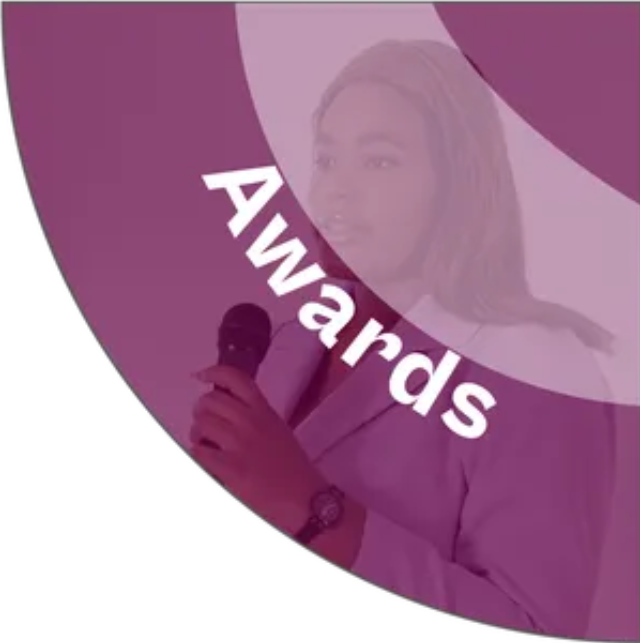 A woman is holding a microphone in front of a purple circle that says awards