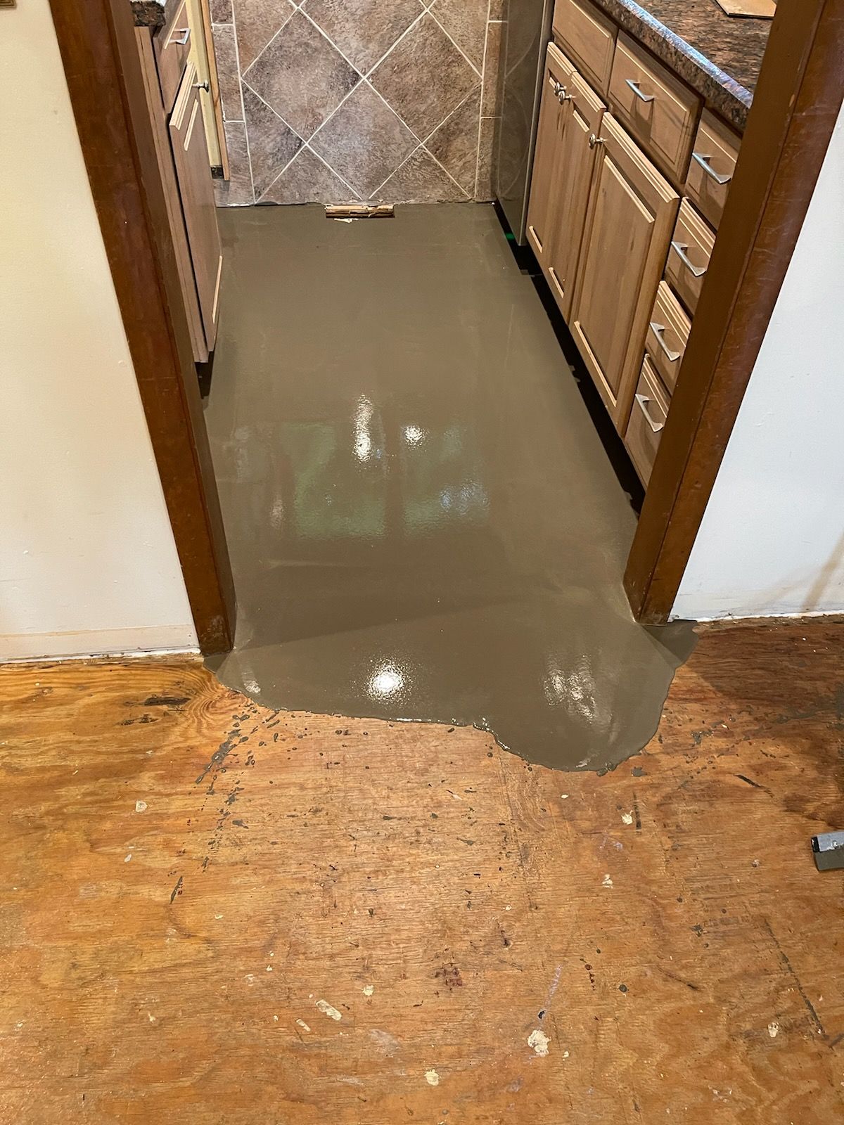 A kitchen floor with a lot of concrete on it.