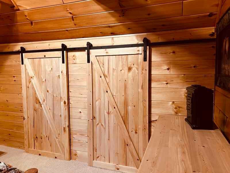 A room with a wooden wall and sliding barn doors.