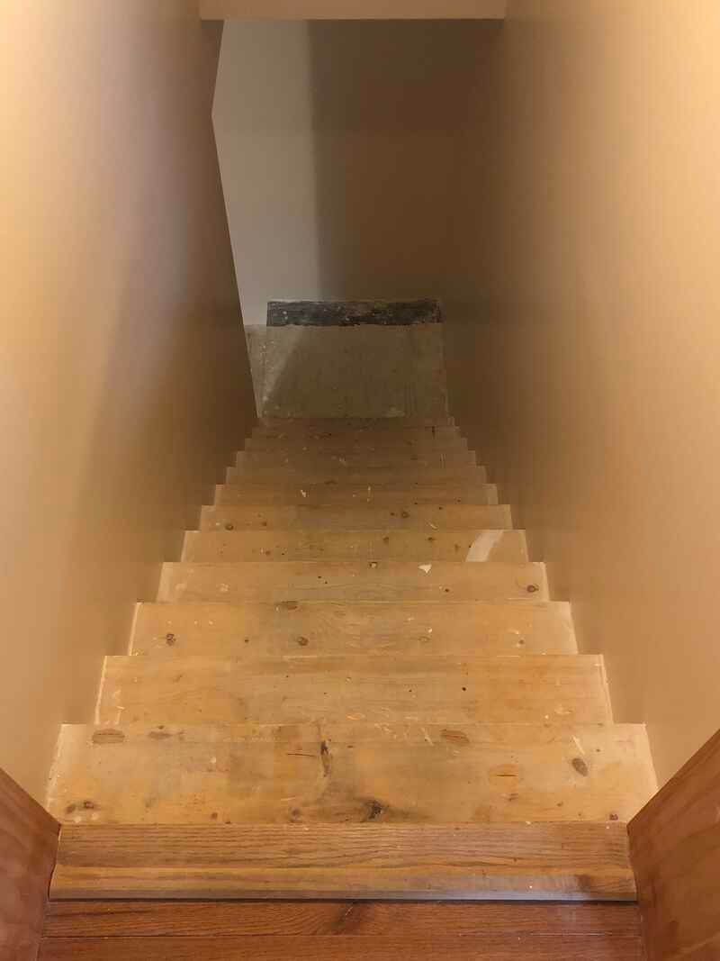 A set of wooden stairs leading up to a basement.