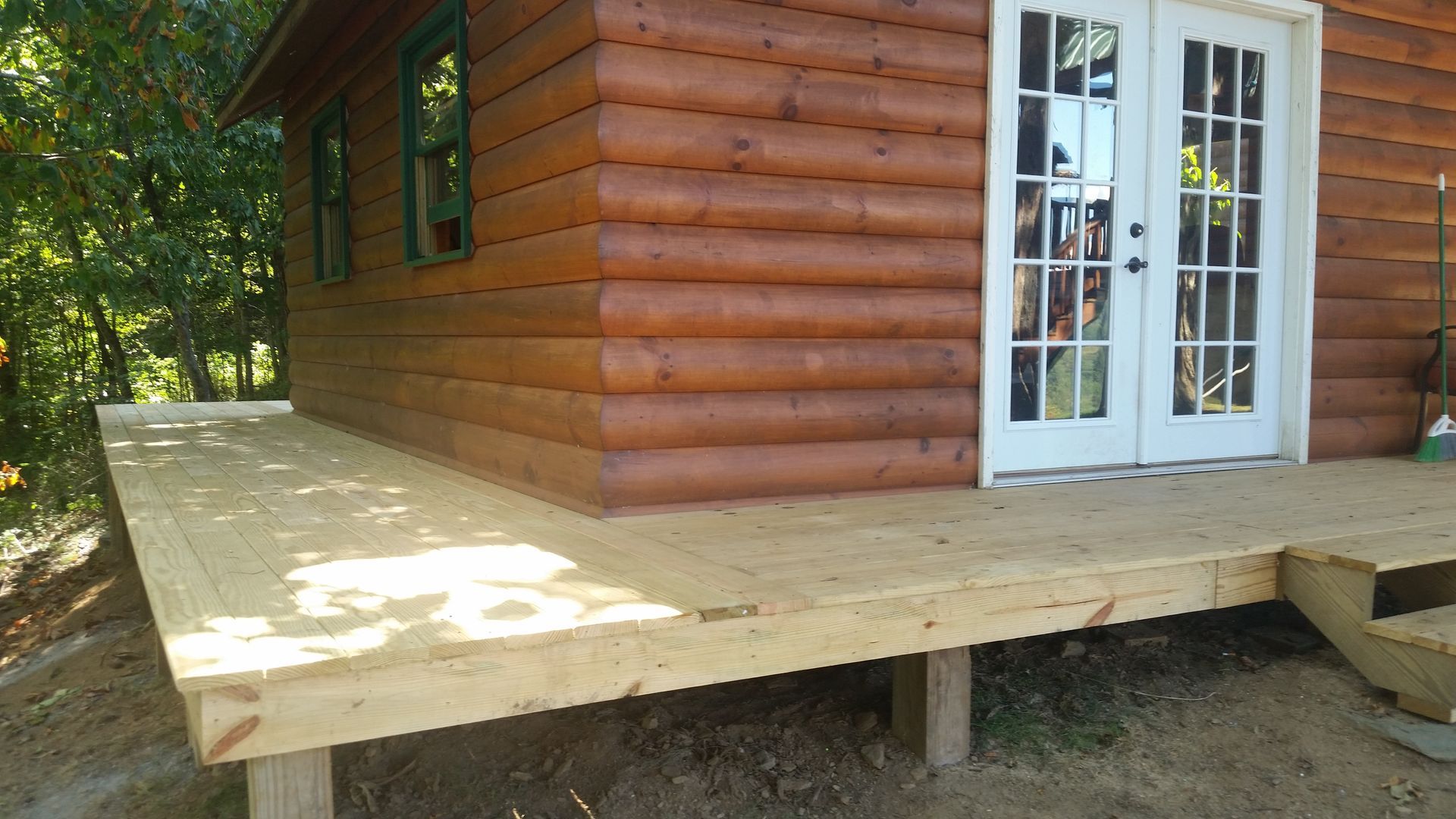 A log cabin with a wooden deck in front of it