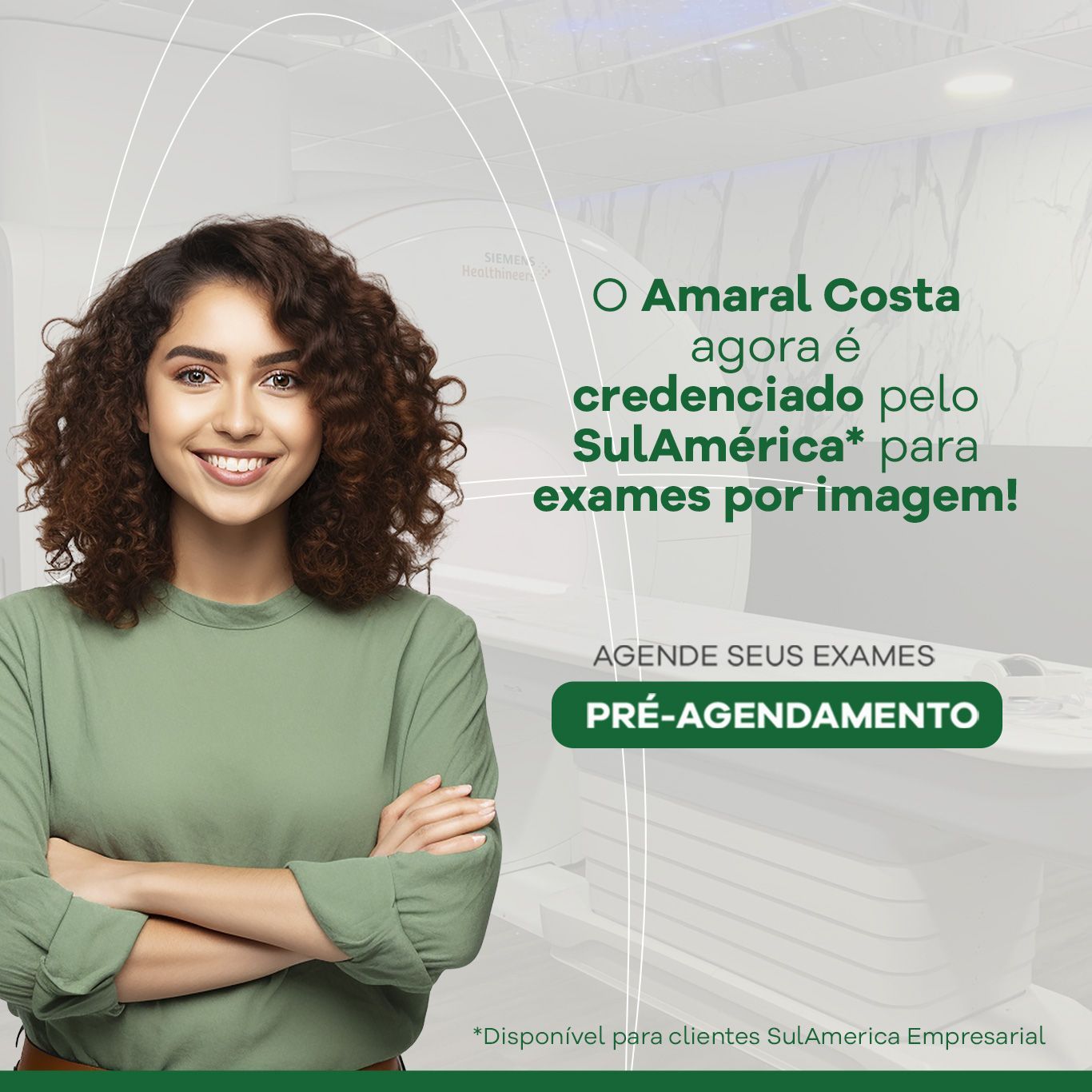 Uma mulher de camisa verde está sorrindo com os braços cruzados.