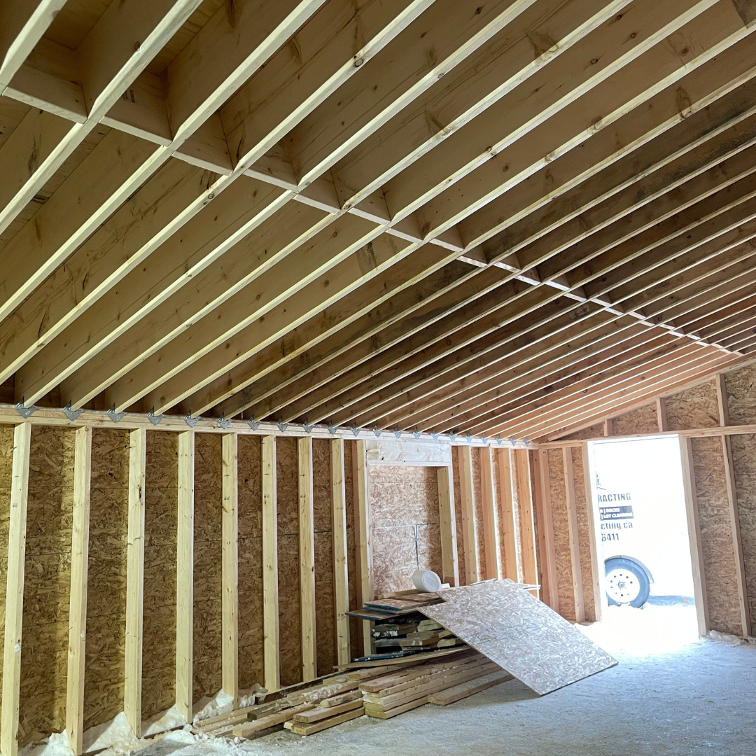 The inside of a building under construction with a car parked in the doorway.