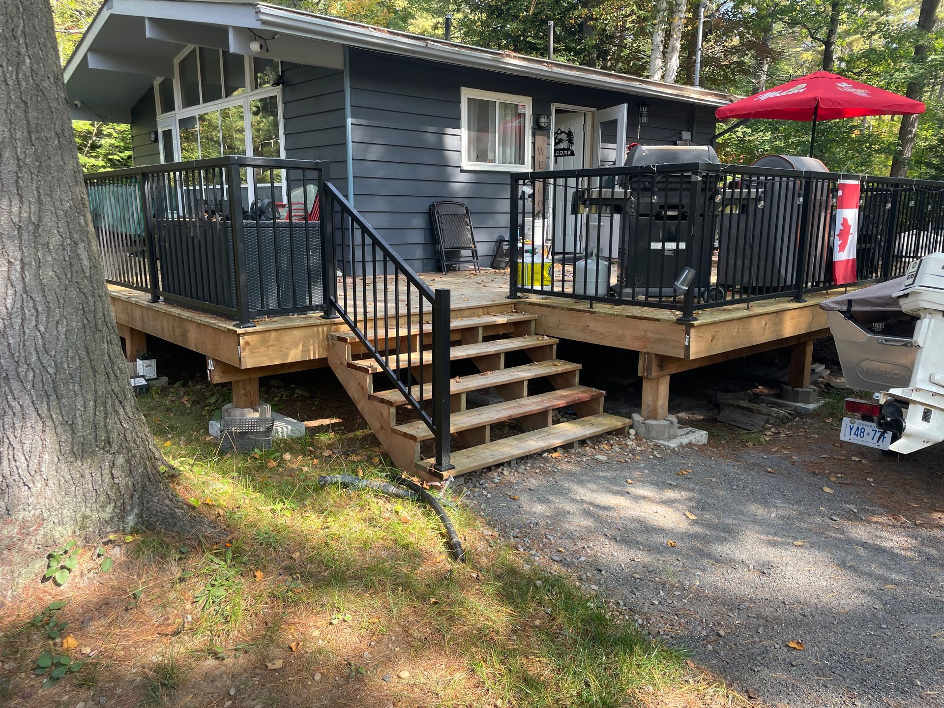 A small house with a deck and stairs in front of it.