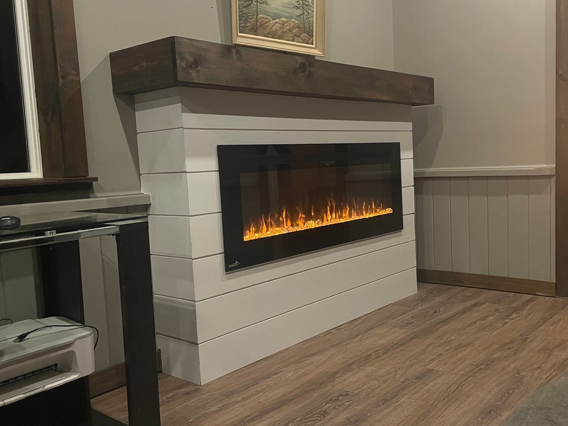 A living room with a fireplace and a wooden mantle.