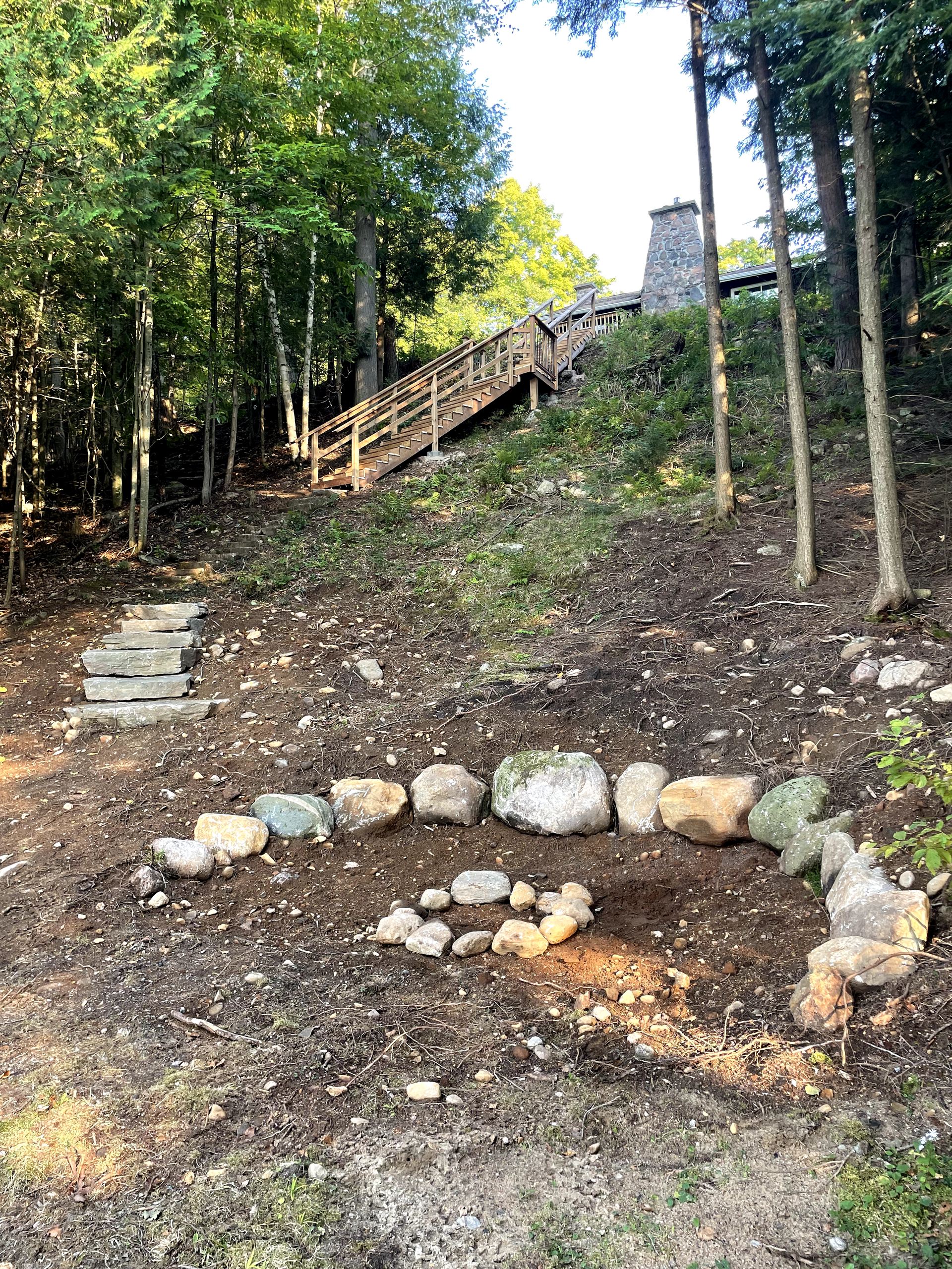 There are stairs leading up to a house in the woods.