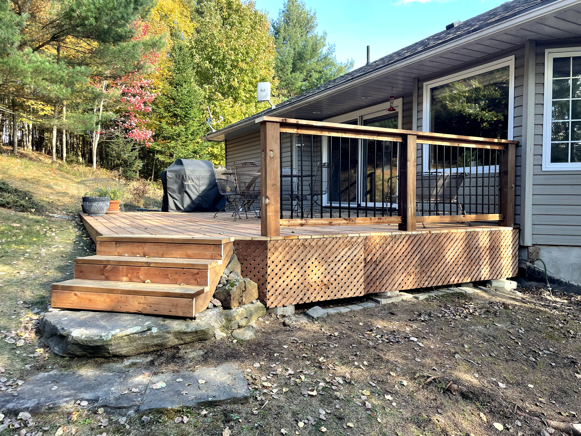 A house with a wooden deck and stairs in front of it.
