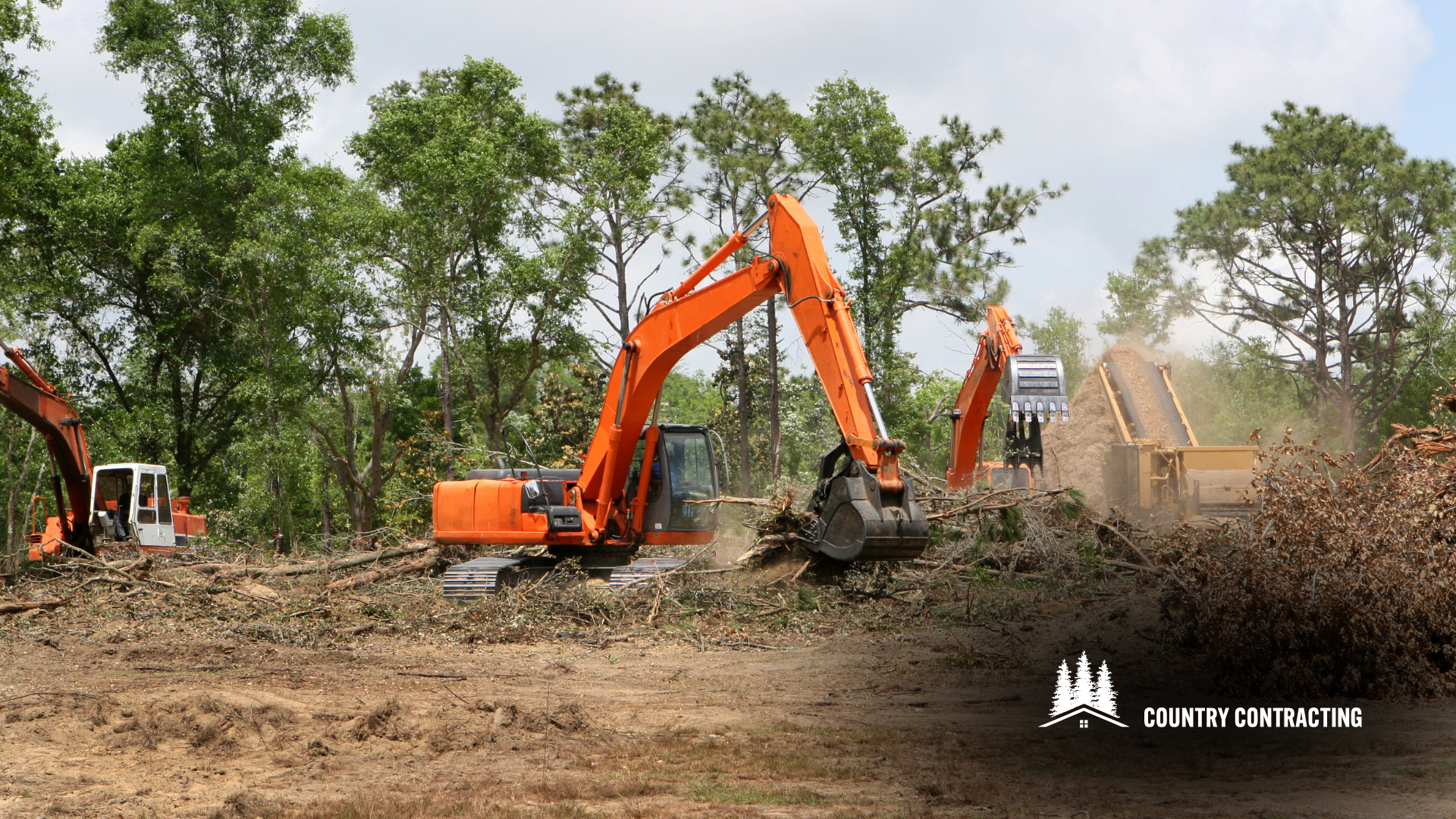 A couple of excavators are working on a dirt field.